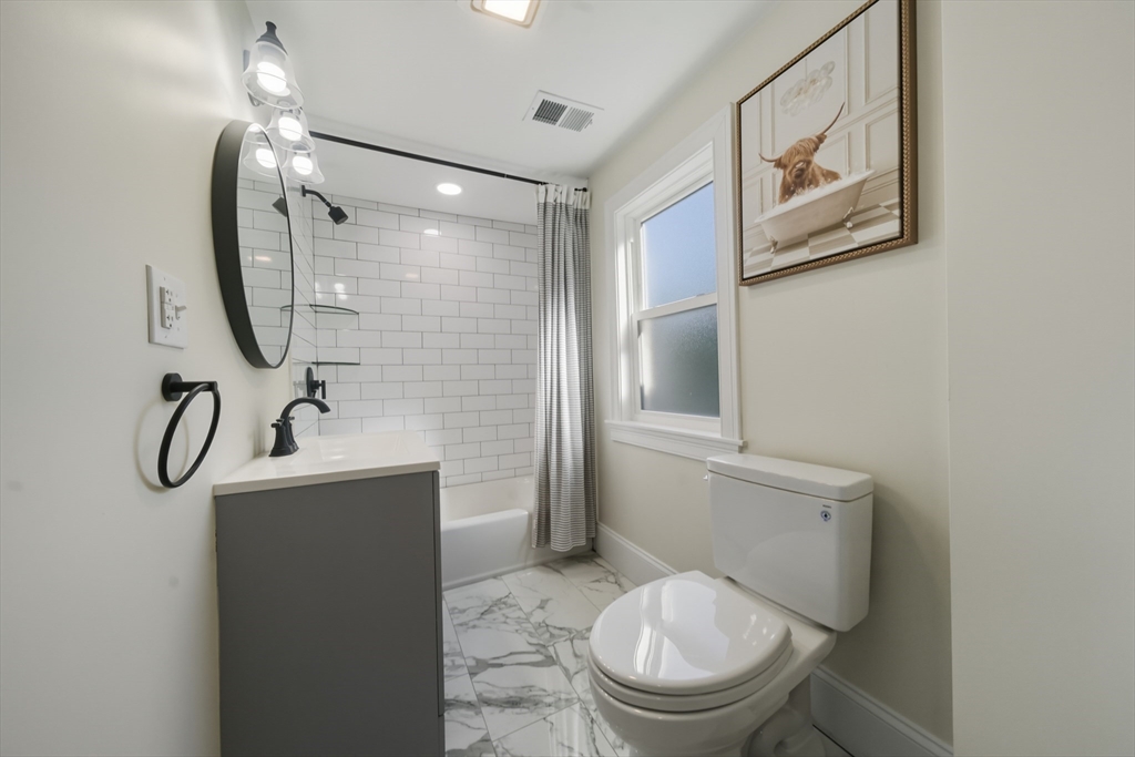 400 Adams Street, Unit A Milton, MA 02186 - Photo 15 of 27 a bathroom with a toilet sink and mirror