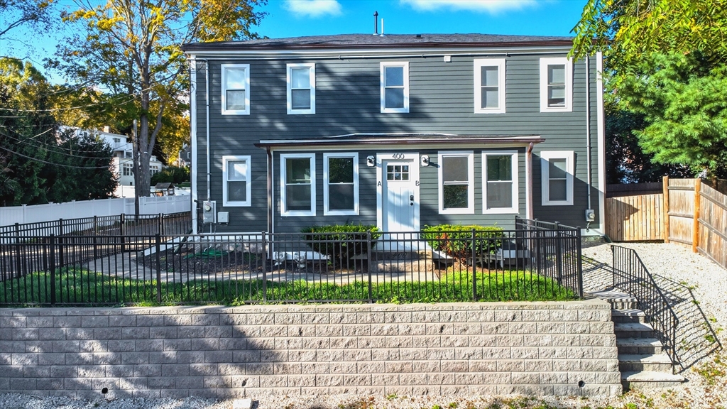 400 Adams Street, Unit A Milton, MA 02186 - Photo 23 of 27 a view of a brick house with a yard and plants