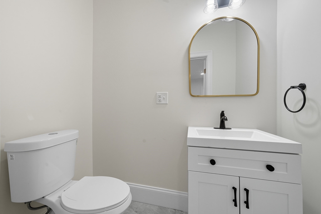 400 Adams Street, Unit A Milton, MA 02186 - Photo 8 of 27 a bathroom with a toilet sink and mirror
