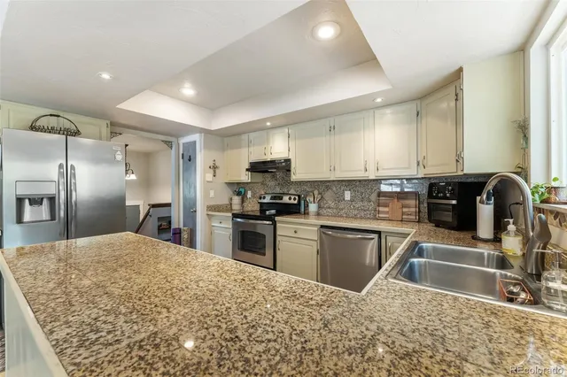 a kitchen with stainless steel appliances granite countertop a stove and a sink