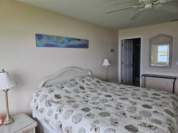 a bedroom with a bed and a lamp on dresser
