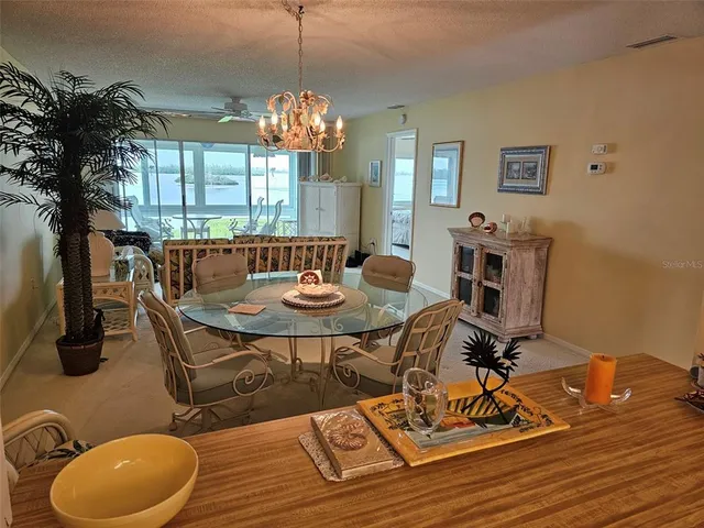 a view of a dining room with furniture a chandelier and wooden floor