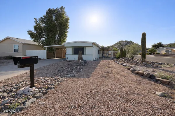 a front view of a house with a yard and mountain view