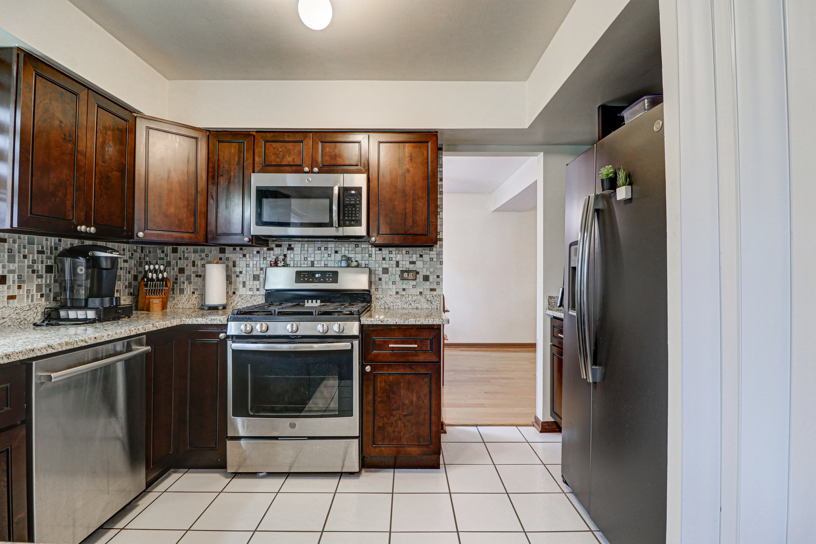 1126 Manchester Road Schaumburg, IL 60193 - Photo 9 of 28 a kitchen with stainless steel appliances granite countertop a refrigerator stove and sink