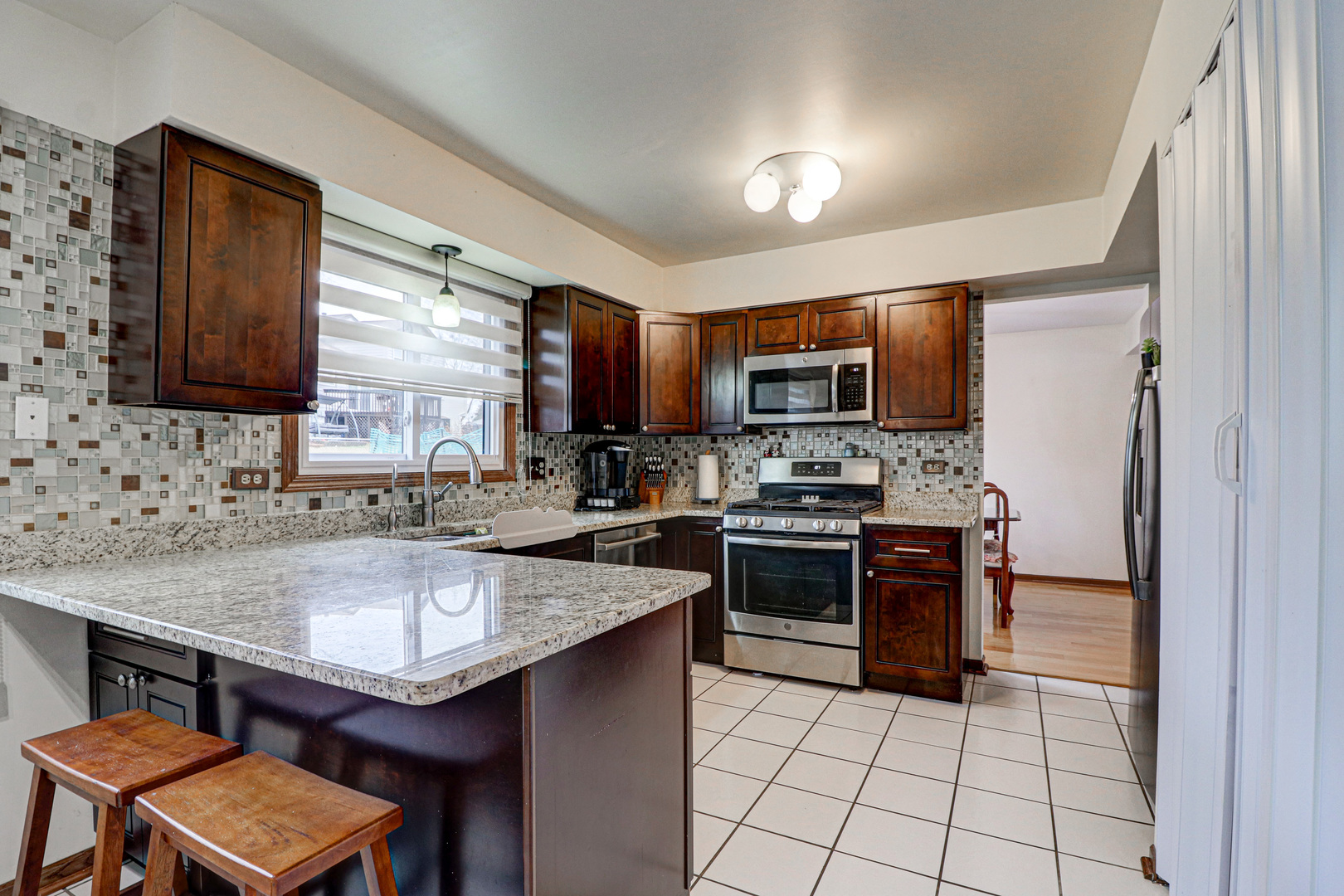 1126 Manchester Road Schaumburg, IL 60193 - Photo 10 of 28 a kitchen with a sink a stove a microwave and a refrigerator
