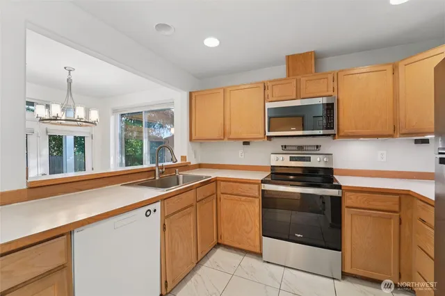 a kitchen with granite countertop a sink stainless steel appliances and cabinets