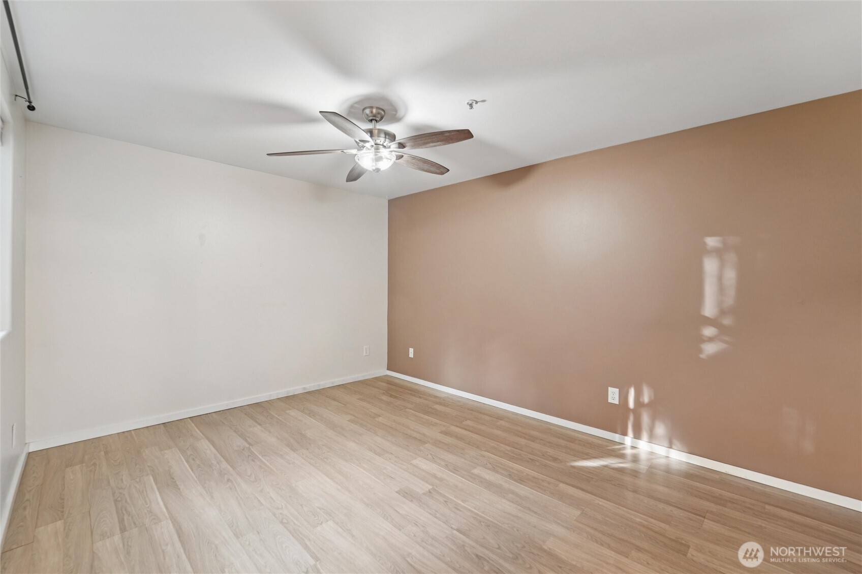 8515 244th Street Southwest, Unit A5 Edmonds, WA 98026 - Photo 14 of 20 an empty room with wooden floor and fan