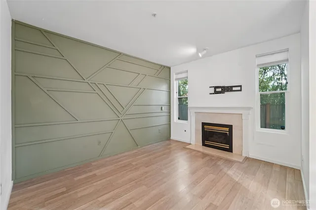 a view of empty room with wooden floor and fireplace