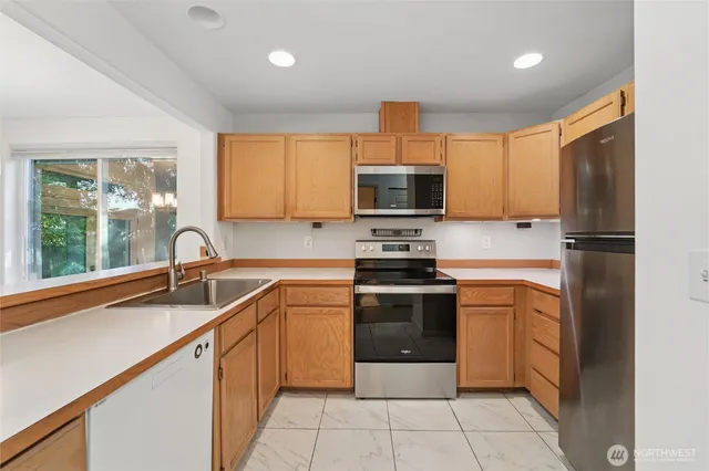 a kitchen with stainless steel appliances a sink cabinets and a refrigerator