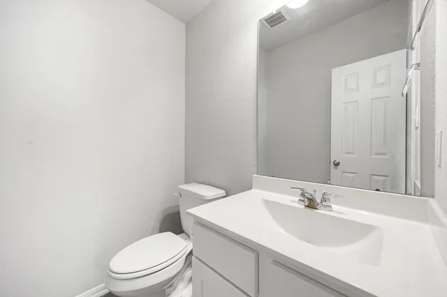 a bathroom with a toilet a sink and mirror