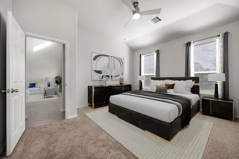 a spacious bedroom with a large bed and a chandelier