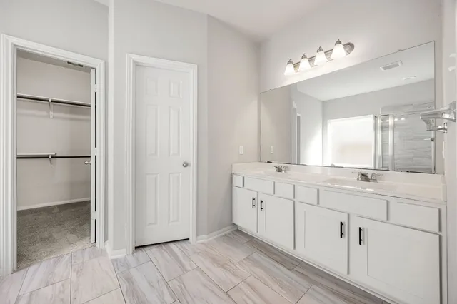 a bathroom with a double vanity sink and mirror