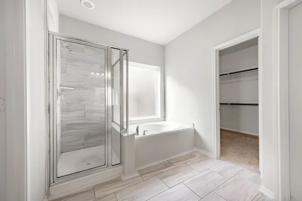 a bathroom with a glass shower door and a bathtub