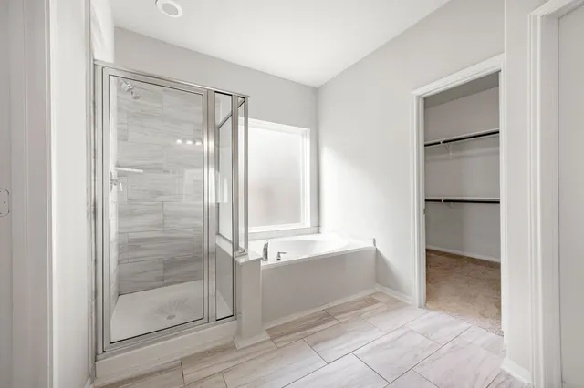 a bathroom with a glass shower door and a bathtub