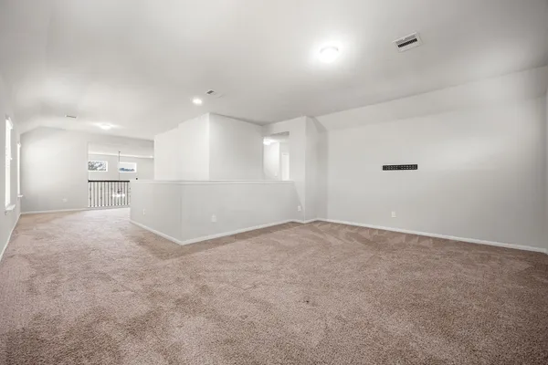 a view of an empty room and a kitchen