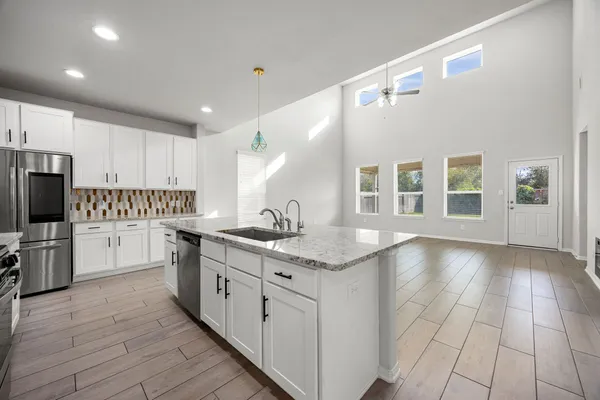 a kitchen with a sink cabinets and wooden floor