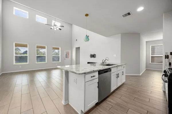 a large kitchen with granite countertop a stove and a sink
