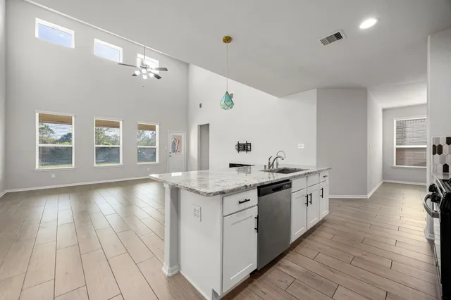 a large kitchen with granite countertop a stove and a sink