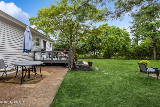 a view of a house with backyard and sitting area