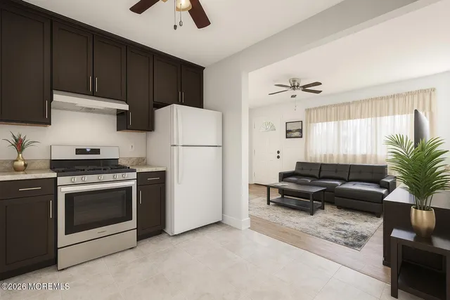 a kitchen with furniture a refrigerator and a stove top oven