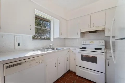 237 Briarwood Drive Kingsville, TX 78363 - Photo 5 of 13 a kitchen with white cabinets and white appliances