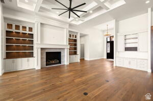 1141 East Lost Ridge Drive Washington, UT 84780 - Photo 29 of 108 Expansive living space featuring wood-finish flooring, a coffered ceiling with a modern ceiling fan, and a fireplace with a stone surround