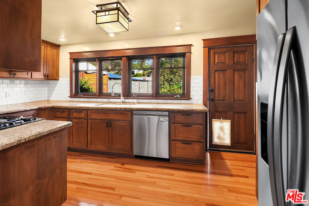 1436 Silver Boulevard Los Angeles, CA 90026 - Photo 10 of 31 a kitchen with stainless steel appliances granite countertop a refrigerator a sink dishwasher a stove and white countertops with wooden floor