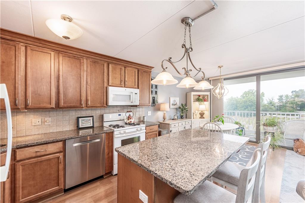1150 Bower Hill Road, Unit 510B Pittsburgh, PA 15243 - Photo 16 of 25 a kitchen with kitchen island granite countertop a sink a counter top space appliances and cabinets
