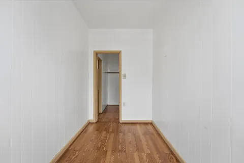 a view of a small space with wooden floor and a window