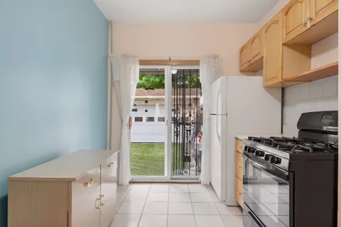 a kitchen with a stove a refrigerator and a wooden cabinets