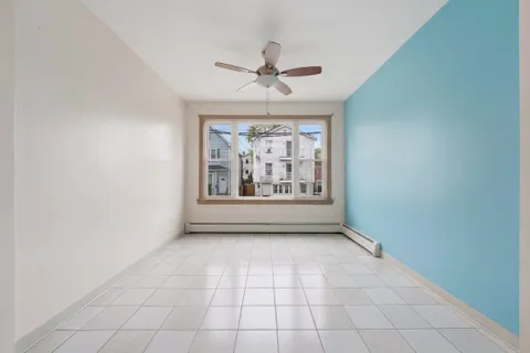an empty room with windows and fan