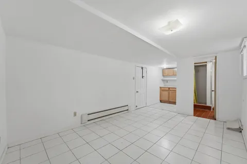 a view of a kitchen with refrigerator and white walls