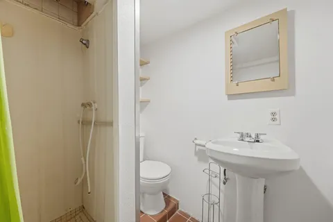 a bathroom with a toilet sink and mirror