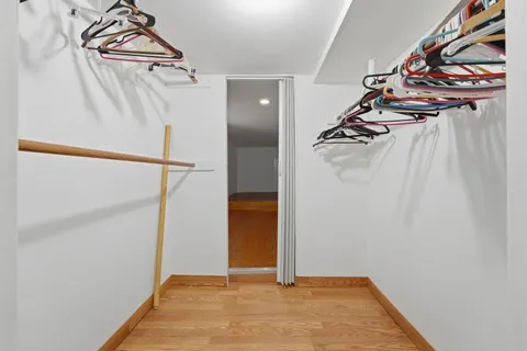 a view of walk in closet with clothes and shoes
