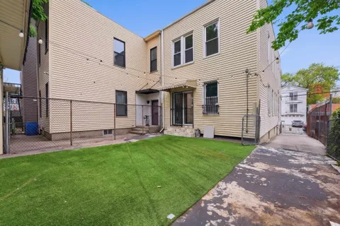 a view of a white house with a yard and table