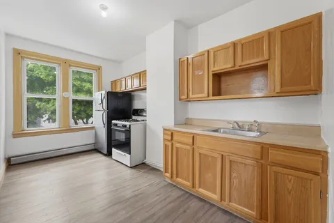 a kitchen with stainless steel appliances granite countertop a stove a sink and a microwave