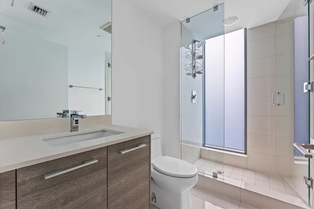 a bathroom with a sink a toilet and shower