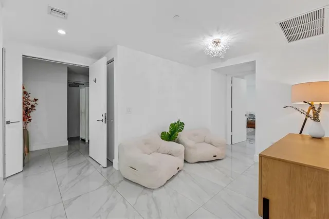 a spacious bedroom with a bed and a chandelier