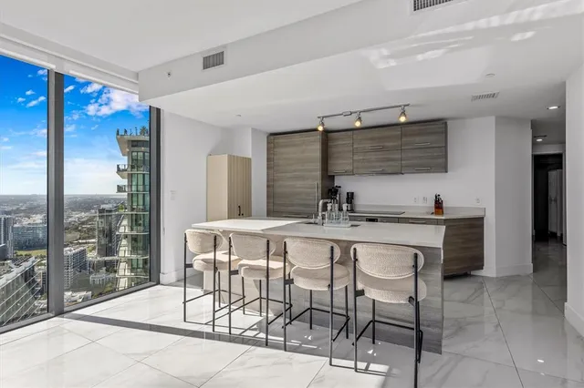 a dining hall with stainless steel appliances kitchen island granite countertop a sink and cabinets