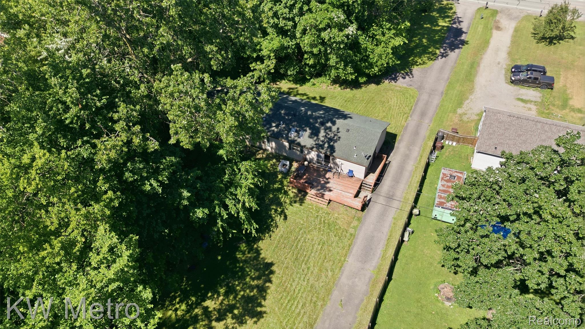 22733 Sumpter Road Belleville, MI 48111 - Photo 43 of 52 Single-story residence featuring a dark-toned roof, light-colored siding, and a prominent wood-finish deck