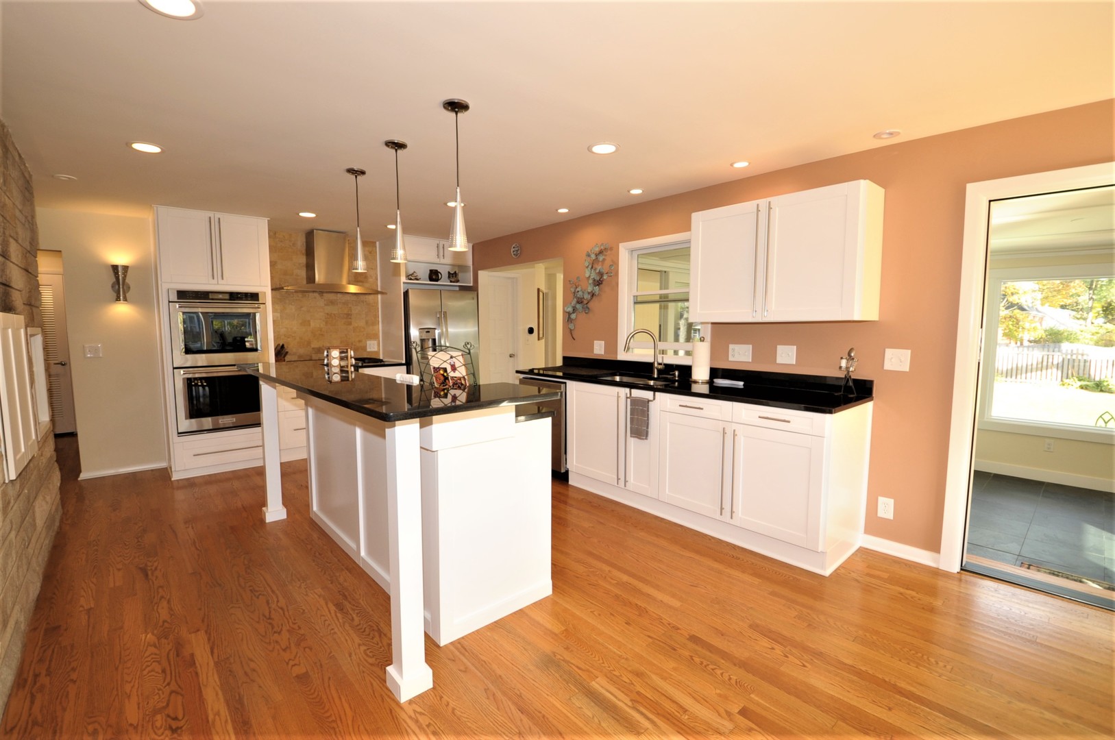 425 Maple Lane Geneva, IL 60134 - Photo 16 of 48 a kitchen with stainless steel appliances kitchen island granite countertop a stove a sink a refrigerator and white cabinets with wooden floor