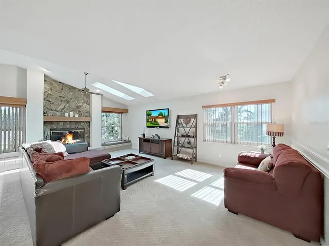 a living room with furniture a chandelier and a dining table with wooden floor