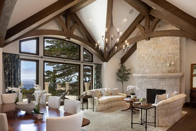 a living room with furniture a chandelier and a fireplace