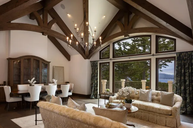 a living room with furniture a chandelier and a large window