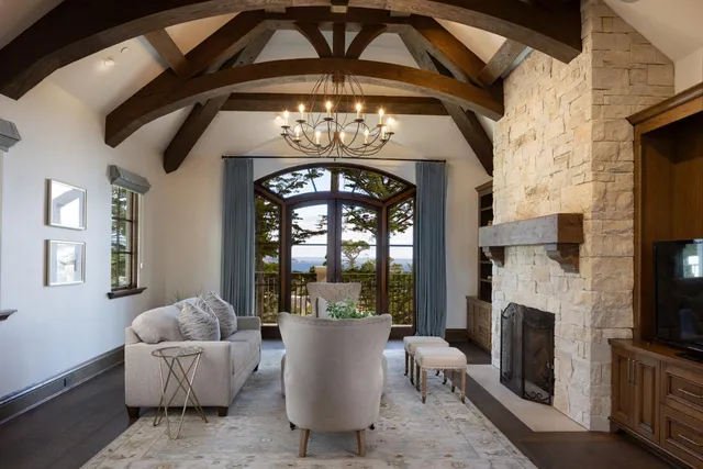 a living room with furniture a fireplace and a chandelier