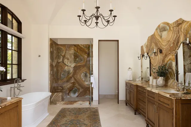 a spacious bathroom with a bathtub sink and mirror