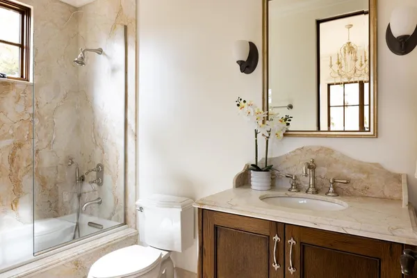 a bathroom with a granite countertop sink toilet and shower