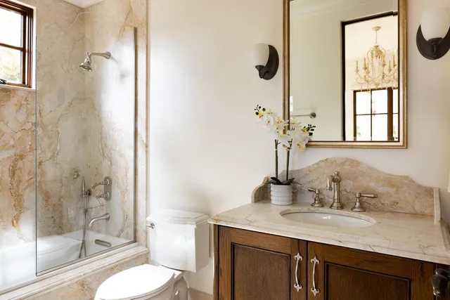 a bathroom with a granite countertop sink toilet and shower