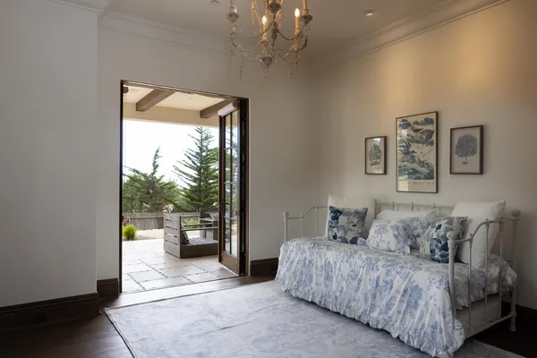 a spacious bedroom with a balcony a bed and a window