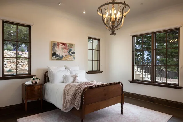 a bedroom with a bed and a large window